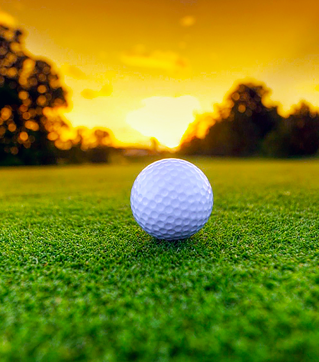 Golf course with golf ball at sunset image